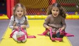 two little girls sitting on a play mat